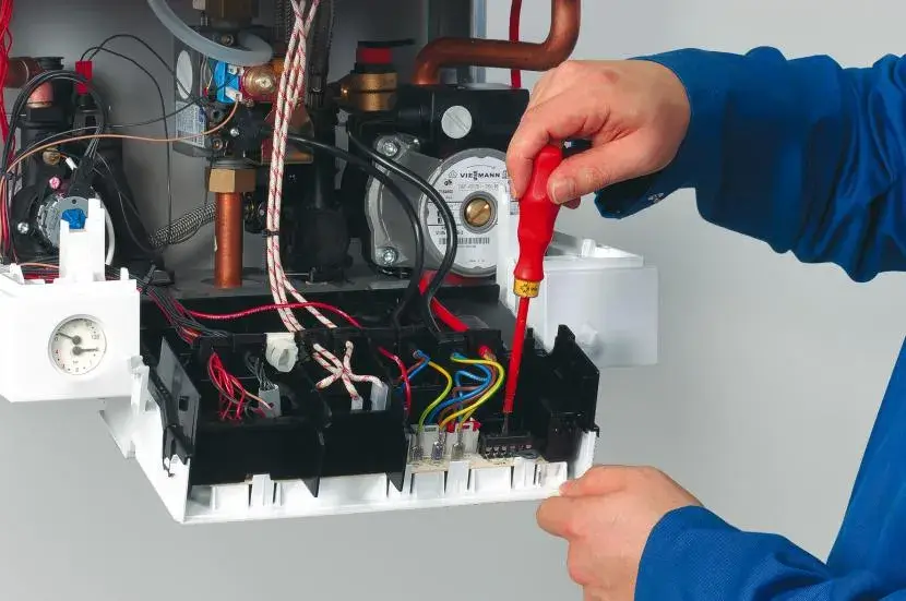 Personne réparant une chaudière